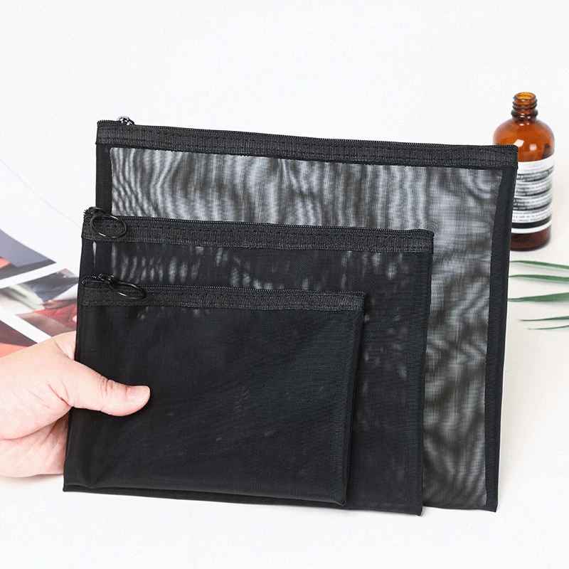 trousses maquillages plates noires 3 dimensions tenue par main